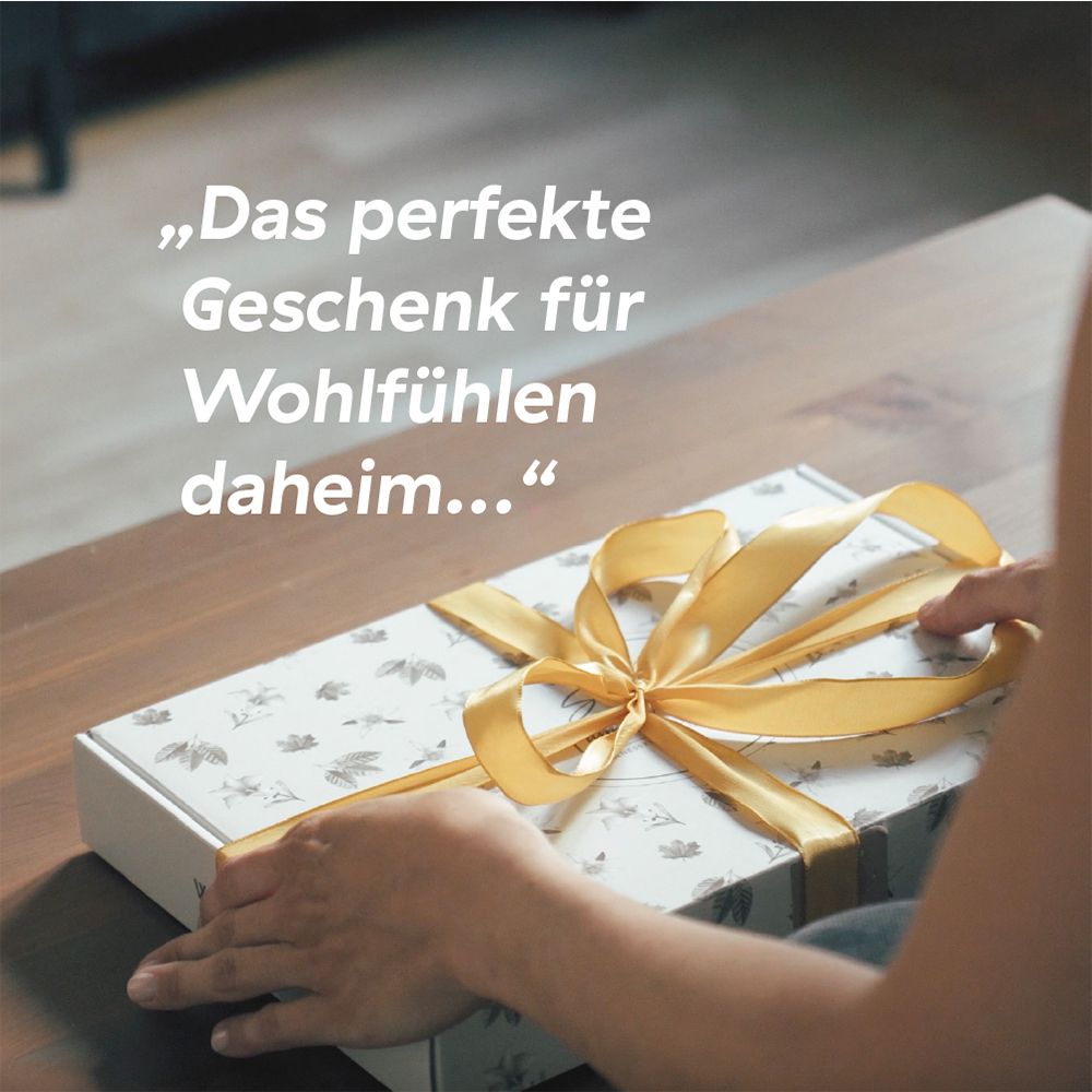 Feestelijk verpakte geschenkdoos met bloemenpatroon en gouden strik.