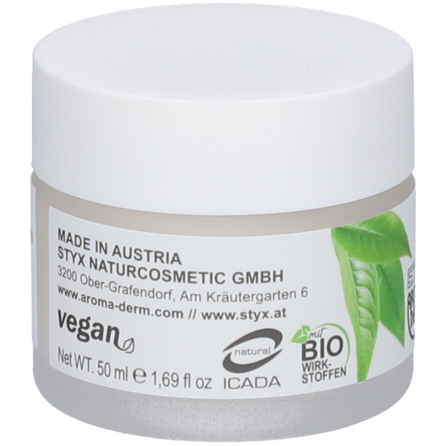 Pot de crème avec couvercle blanc. Étiquette avec texte: Made in Austria, Vegan, certification BIO, adresse. Contenu net 50 ml.