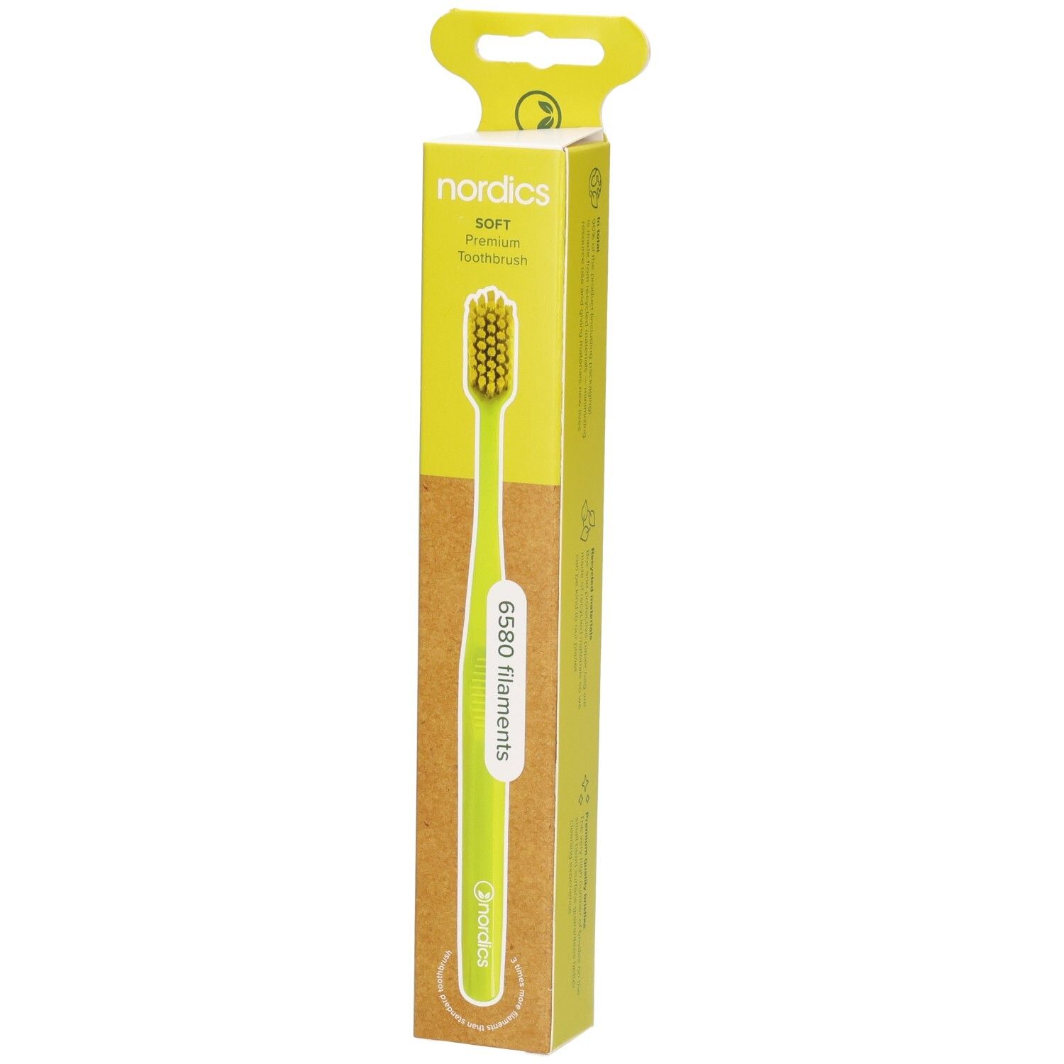 Brosse à dents verte dans son emballage. Marque : nordics. Manche et poils verts. Emballage avec logo et nom du produit.