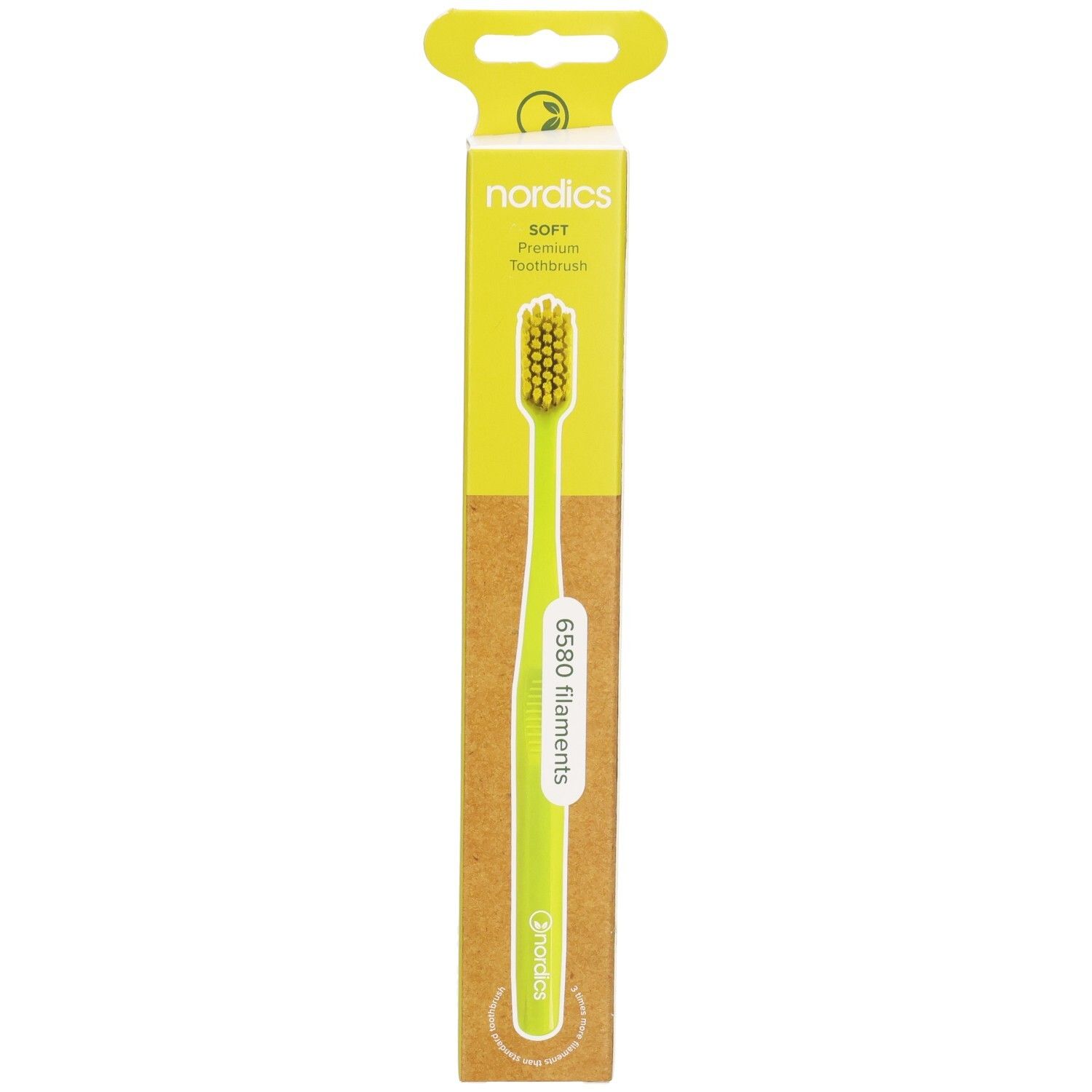 Brosse à dents verte dans son emballage. Marque : nordics. Manche et poils verts. Emballage avec logo et nom du produit.