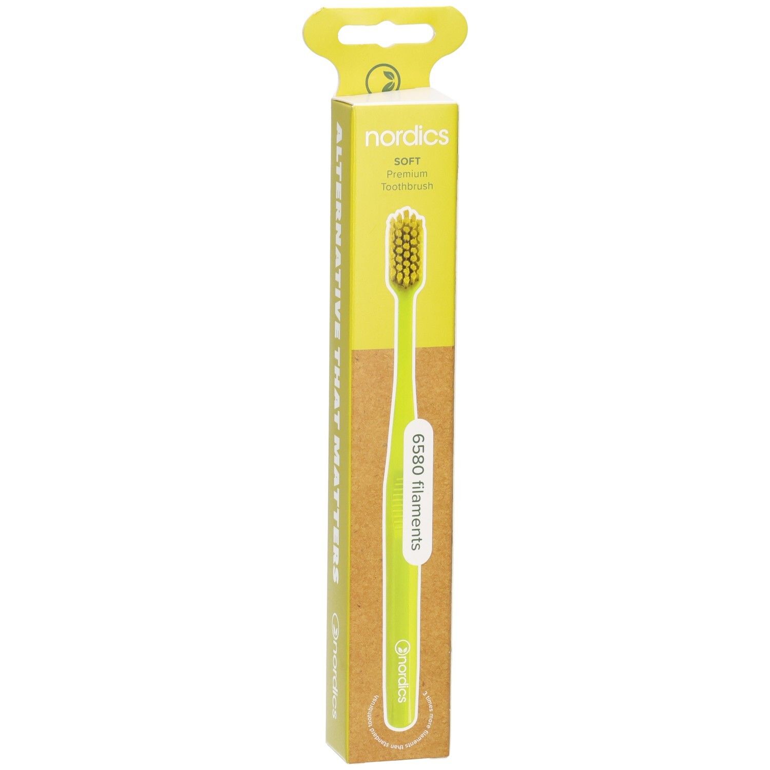 Brosse à dents verte dans son emballage. Marque : nordics. Manche vert, poils clairs. Emballage avec logo et nom du produit.