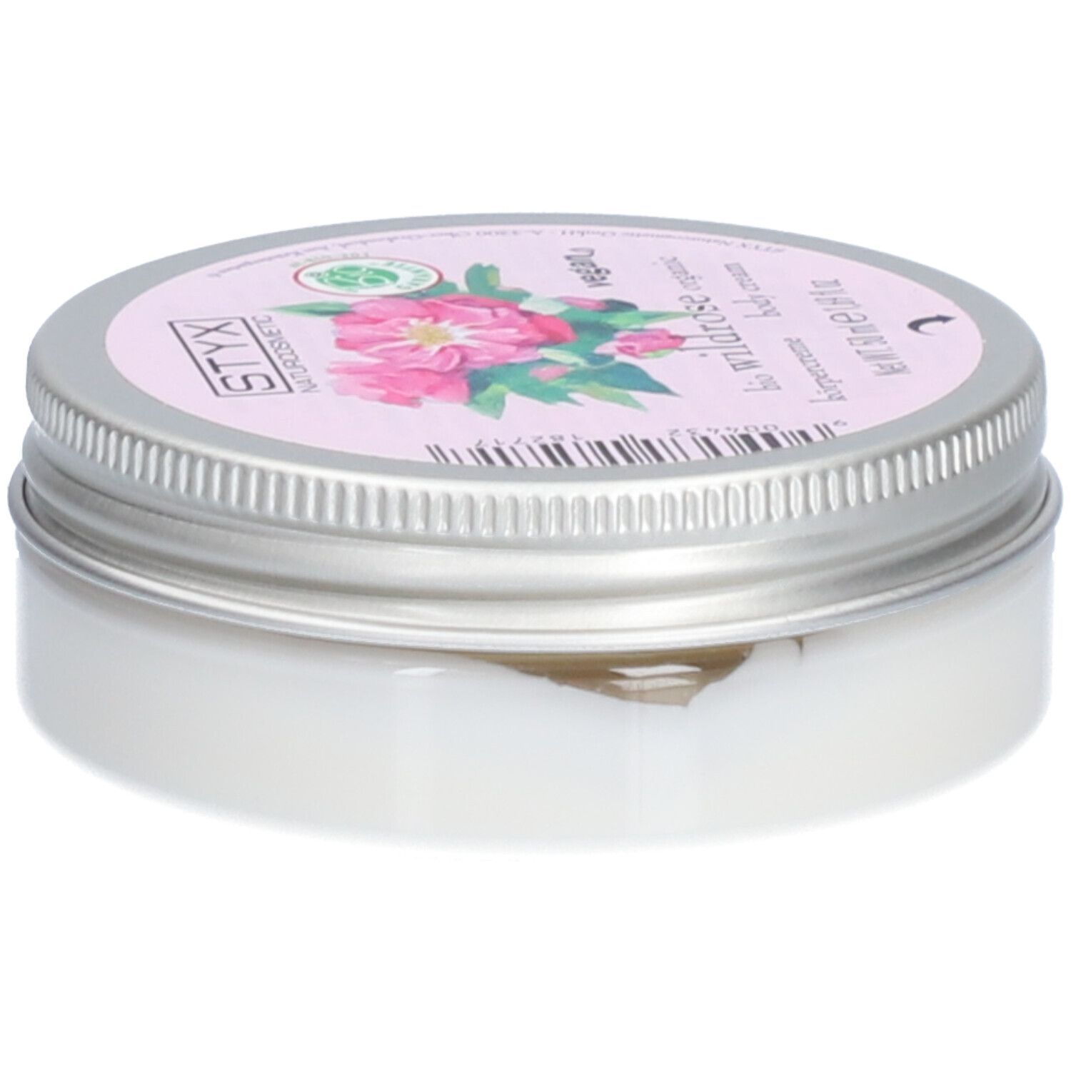 Crèmepot met deksel. Op deksel: STYX Naturkosmetik, Wildrose, vegan. Roze etiket met rozenbloemen. Pot van metaal.
