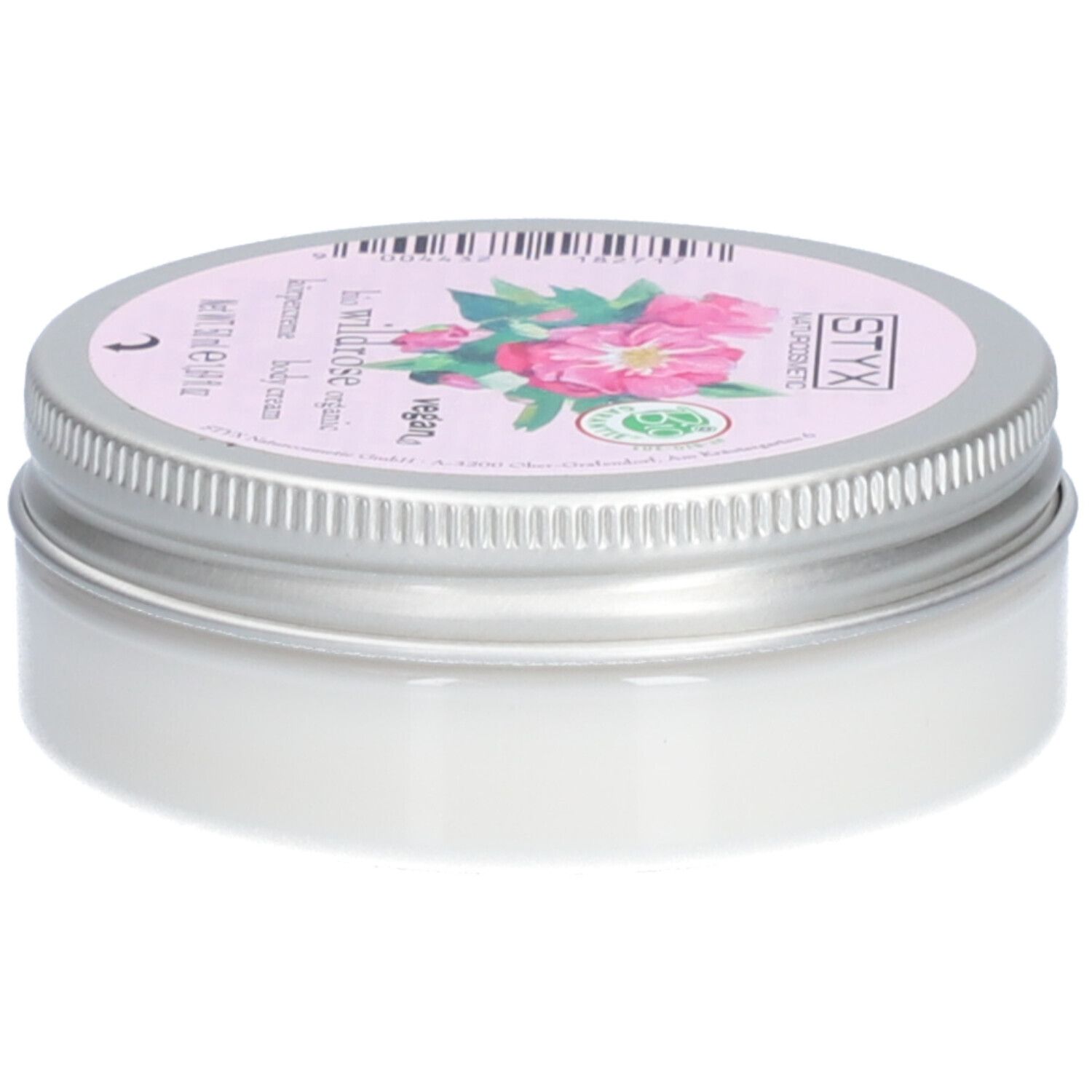 Crèmepot met deksel. Op deksel: STYX Naturkosmetik, Wildrose, vegan. Roze etiket met rozenbloemen. Pot van metaal.