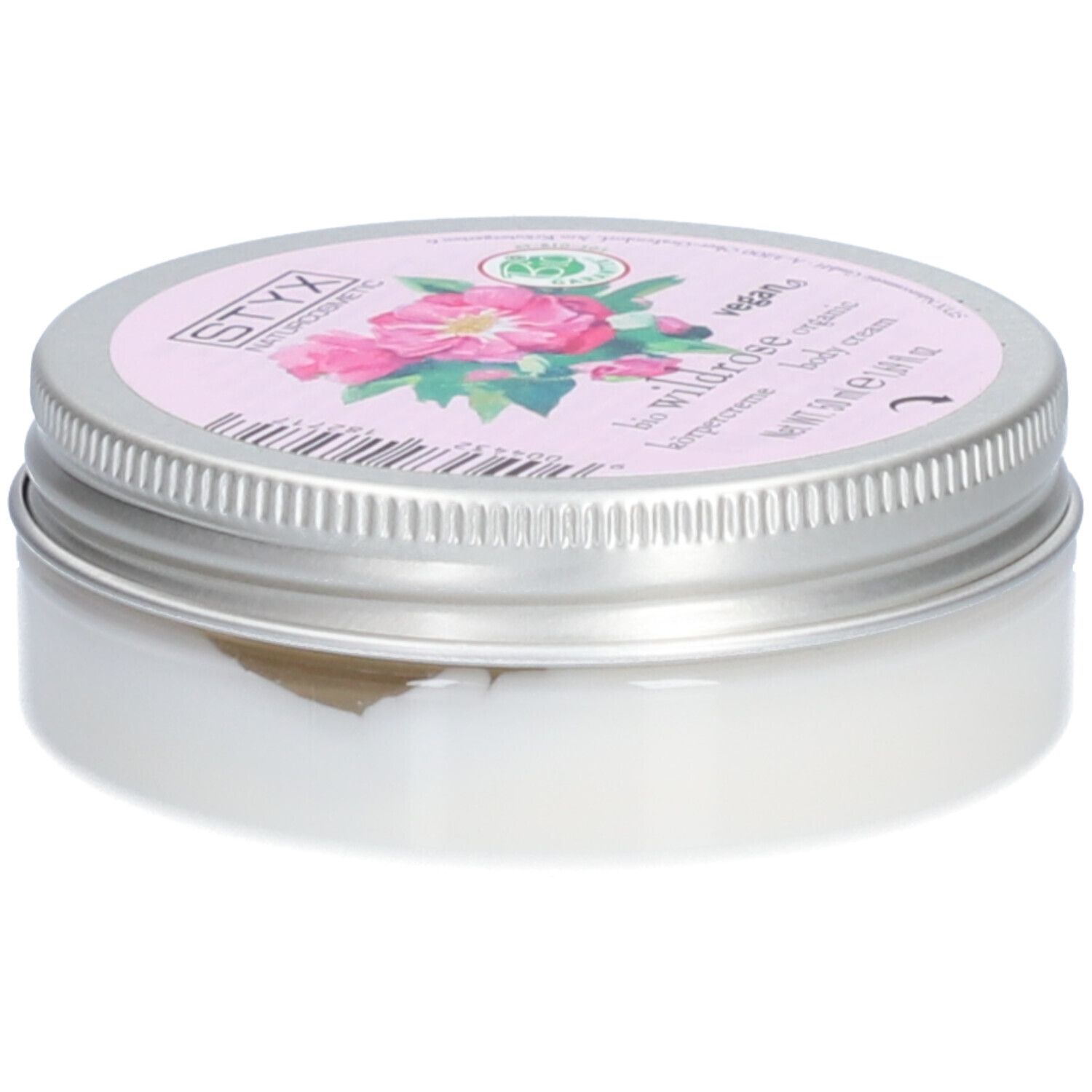 Crèmepot met deksel. Op deksel: STYX Naturkosmetik, Wildrose, vegan. Roze etiket met rozenbloemen. Pot van metaal.