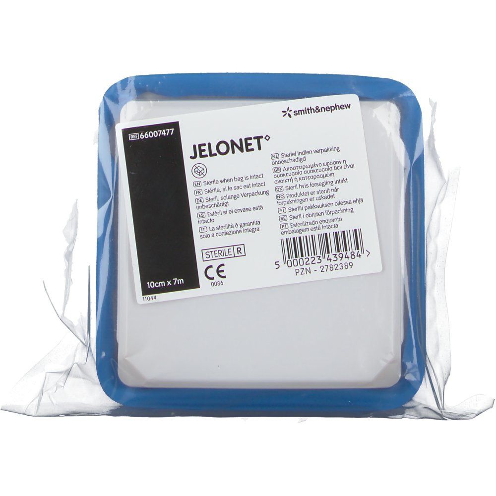 Vierkante wondkompres in blauwe houder, verpakt. Opschrift: JELONET, 10cm x 7m, steriel. Merk Smith & Nephew.