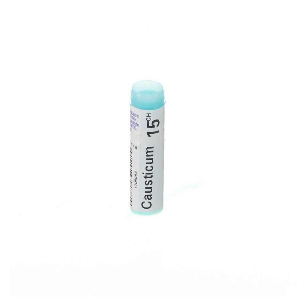 Cilindrische fles met blauwe dop. Opschrift: Causticum 15CH. Wit etiket met tekst en barcode.
