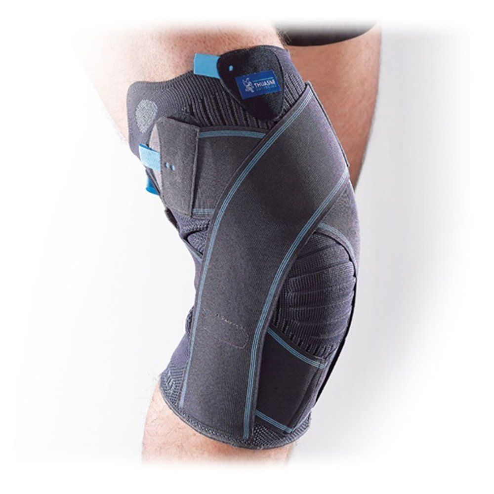 Grijze kniebrace met blauwe accenten. Klittenbandsluitingen en details. Gedragen op een been.