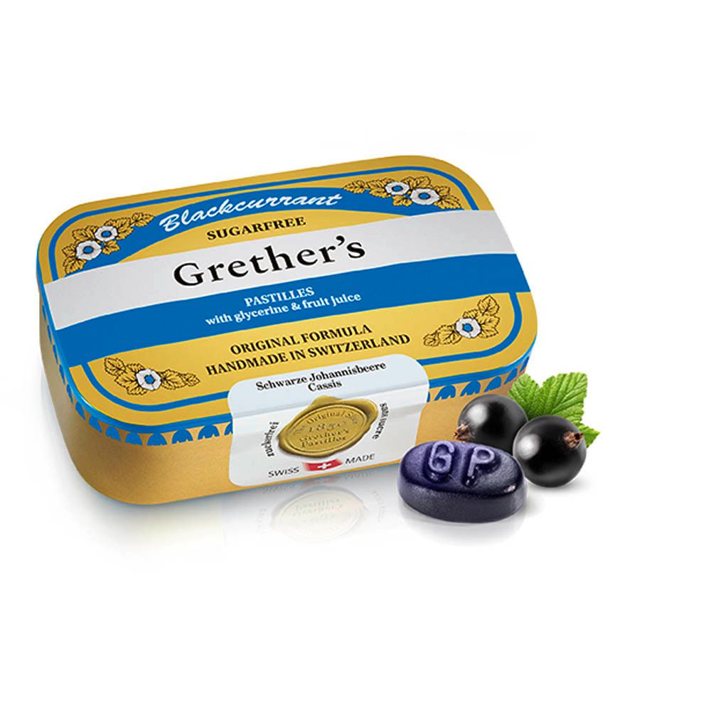 Gouden doos met pastille en zwarte bessen. Opschrift: Grether's Pastilles, suikervrij. Gemaakt in Zwitserland.