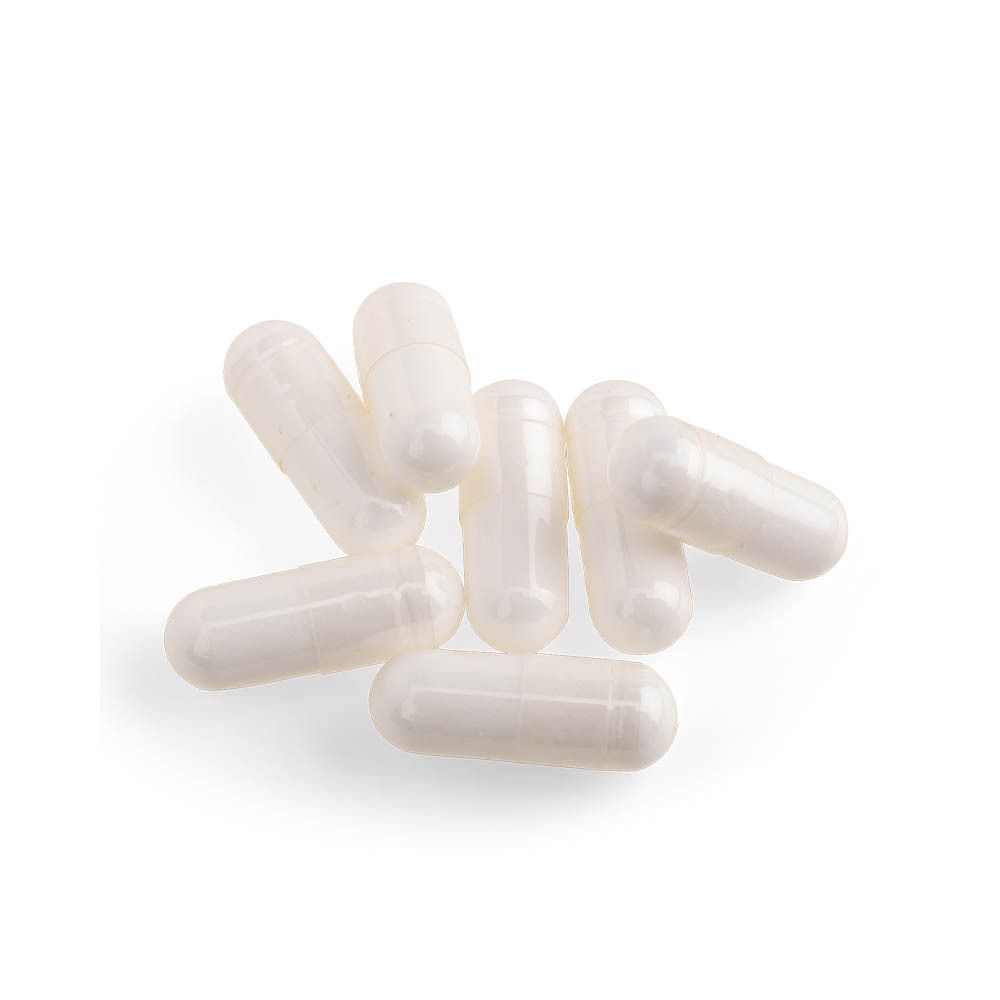 Zeven witte capsules op witte achtergrond. Geen opschrift zichtbaar.