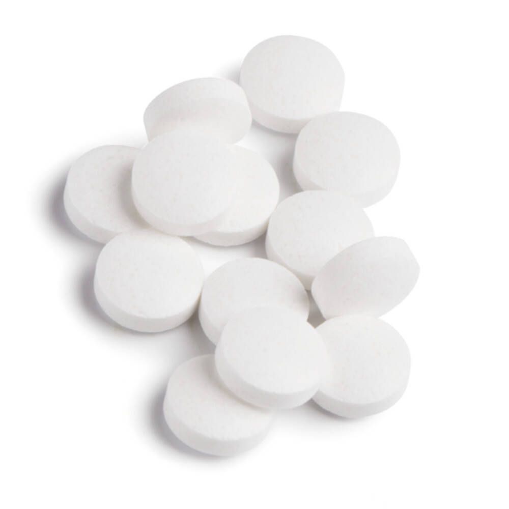 Tas de comprimés blancs et ronds. Aucun emballage visible.