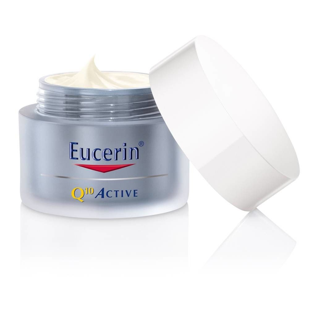 Pot de crème ouvert avec crème visible. Logo Eucerin et texte Q10 Active.