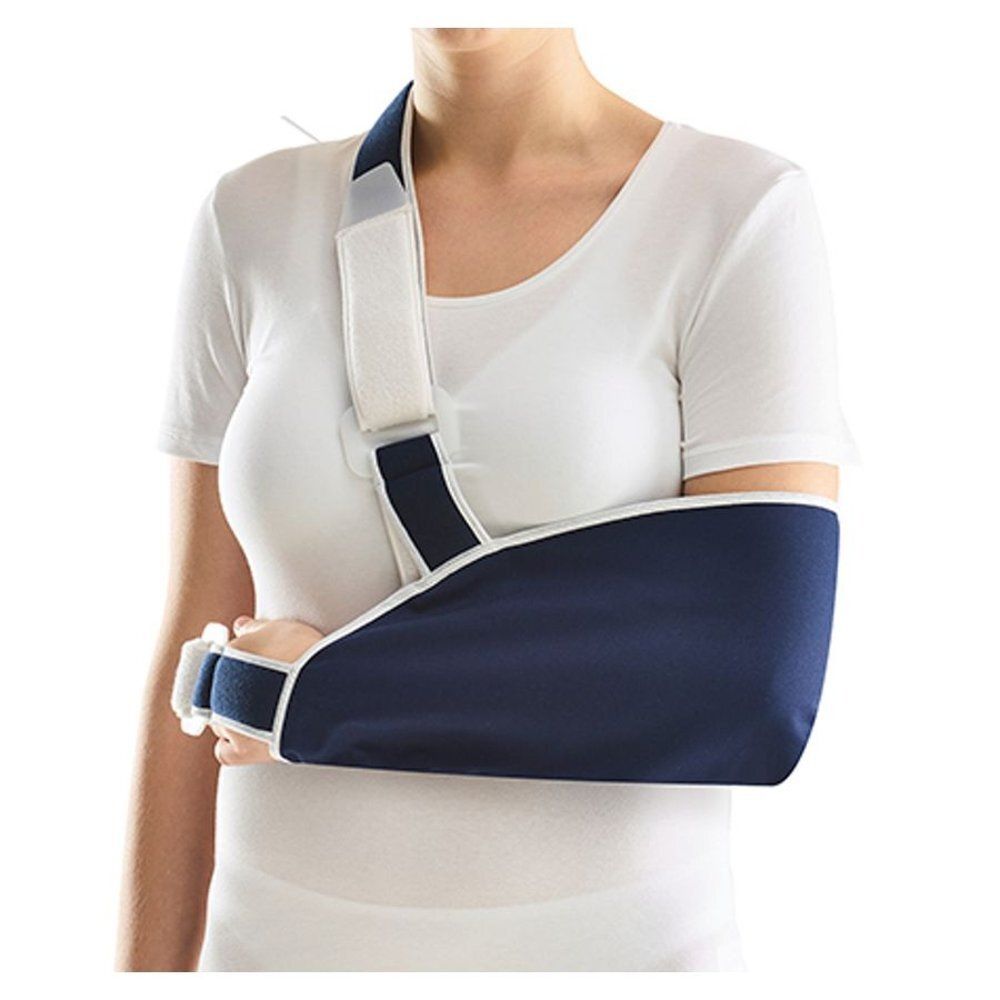 Blauwe armdraagband, witte schouderband. De band ondersteunt de linkerarm. De armdraagband wordt door een vrouw gedragen.