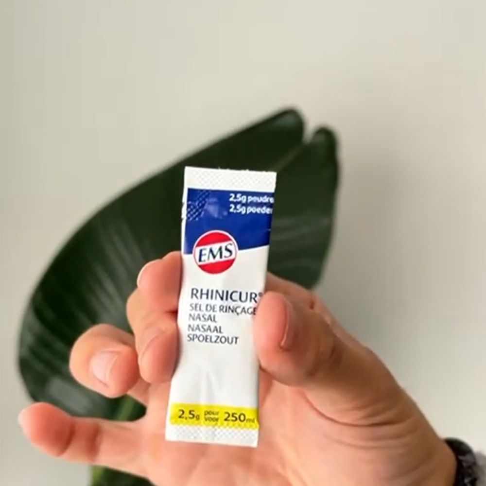 Un sachet de Rhinicur Sel De Rinçage Nasal. Blanc avec texte bleu et rouge. Contient 2,5g de poudre.