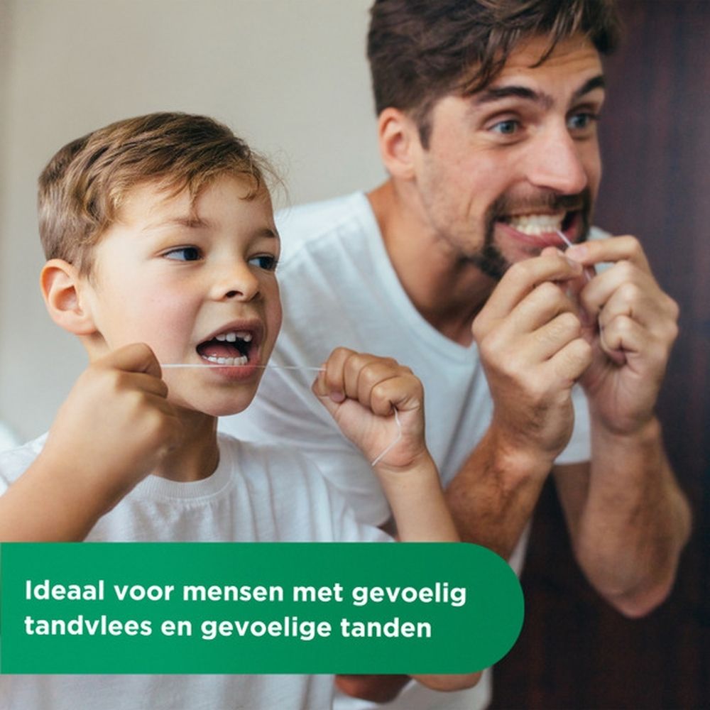 GUM® Expanding Floss, geopend. Witte dispenser met paarse inzet. Draad wordt eruit gehaald. Achtergrond: accessoires.