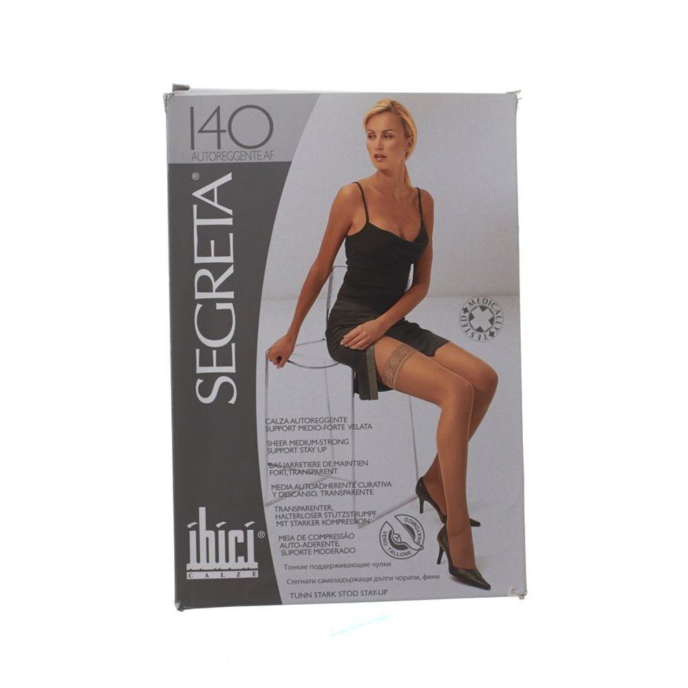 Verpakking met kousen. Opdruk: Segreta, 140, ibici. Vrouw draagt beige kousen, zwarte jurk, hoge hakken. Italiaanse tekst.
