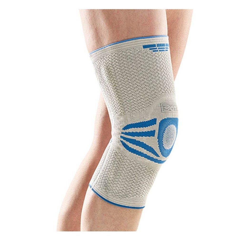 Grijze Bota Ortho kniebrace, maat 7, gedragen op been. Blauwe details.