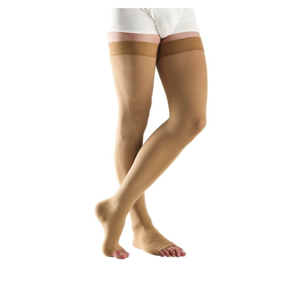 Bas de compression beiges. Montants aux cuisses. Bout ouvert. Nom du produit non visible.