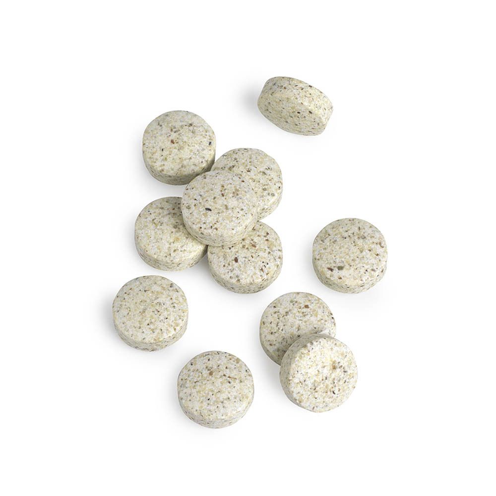 Tabletten van Multi-Mins. Ronde, beige tabletten met kleine puntjes. Op witte achtergrond.