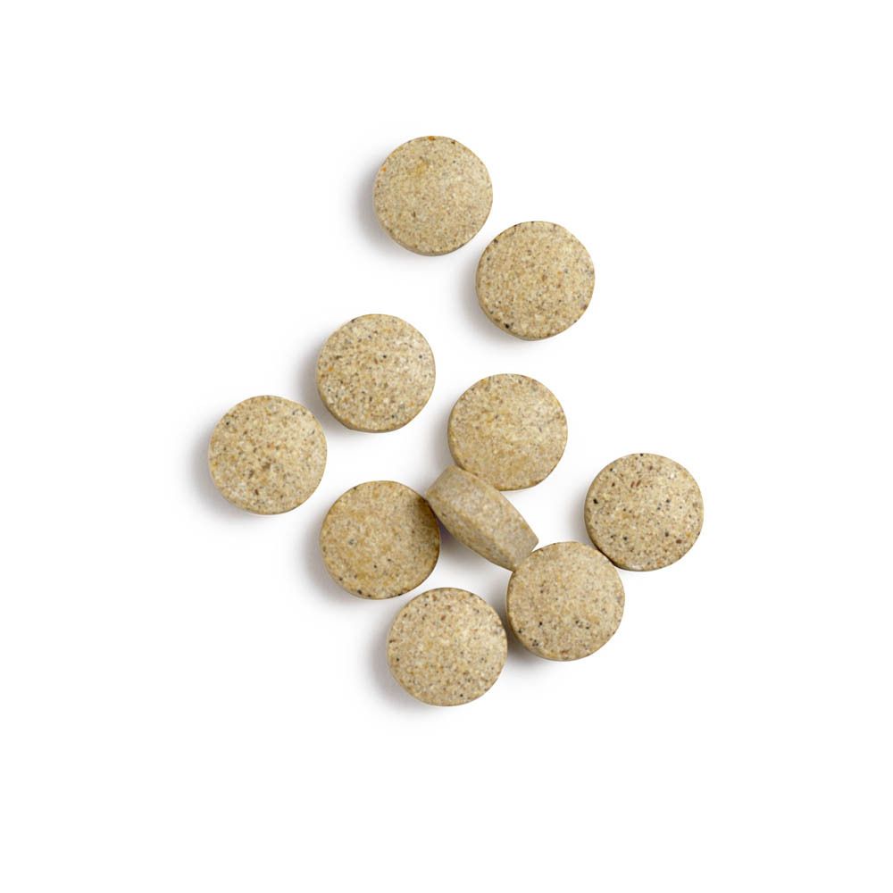 Close-up van tabletten. Ronde, beige tabletten. Enkele tabletten op witte achtergrond.