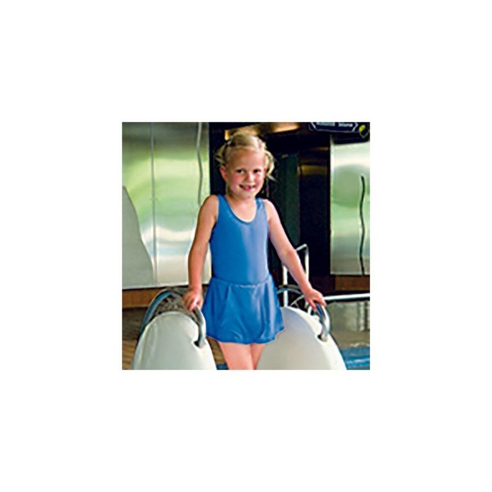 Fille en maillot de bain bleu avec jupe. Debout au bord d'une piscine, elle tient des poignées.