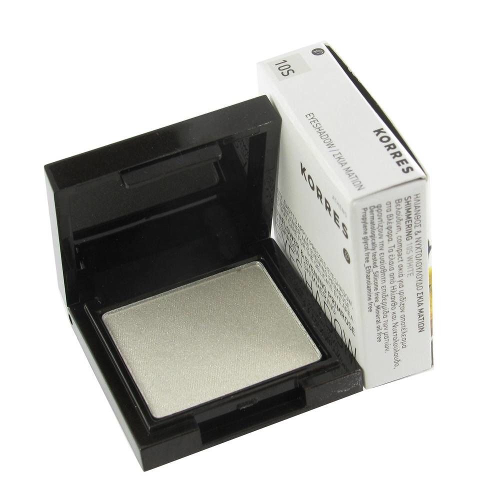 Boîtier de fard à paupières ouvert avec fard à paupières blanc. À côté, un emballage blanc avec du texte. Boîtier noir.