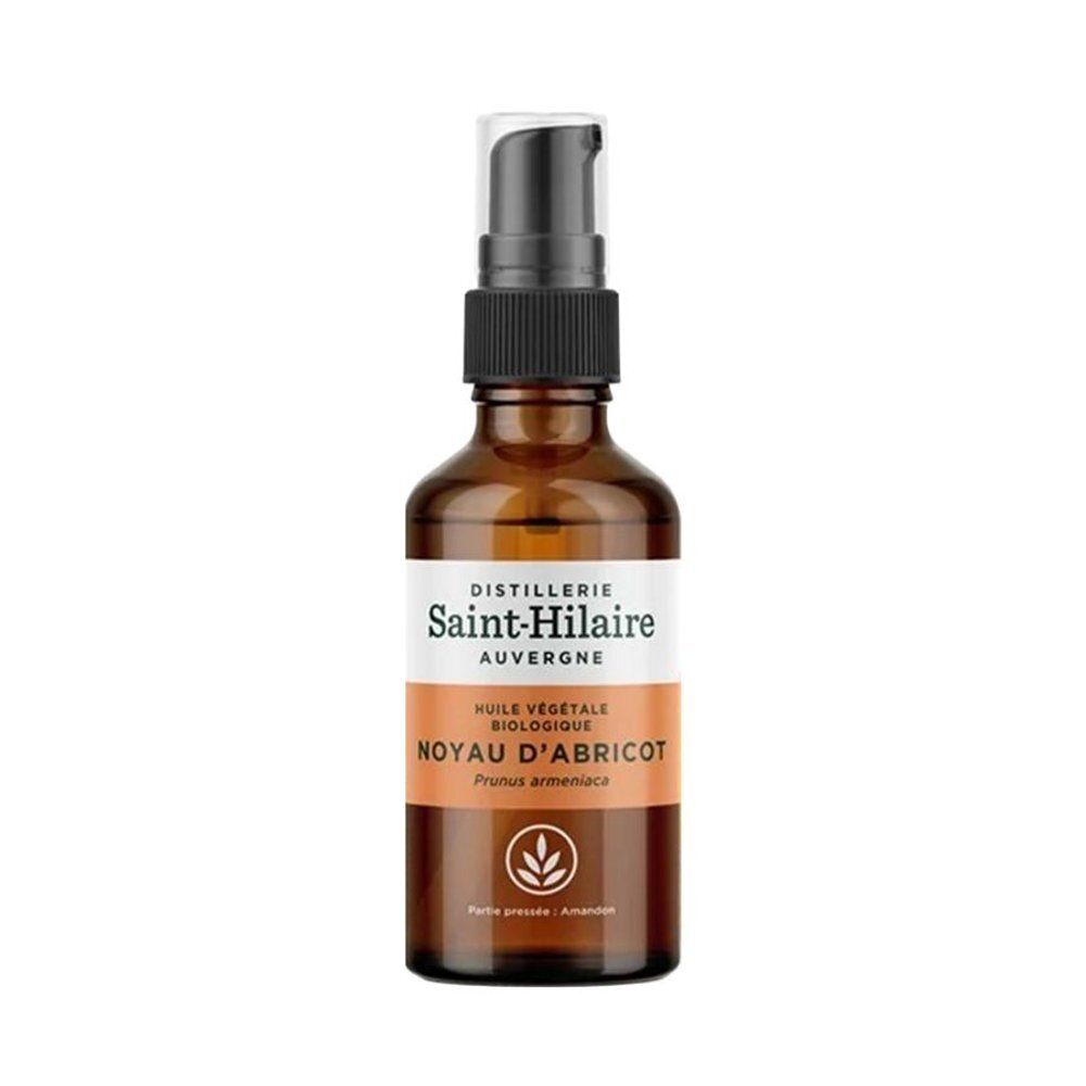 Bruine glazen fles met zwarte pomp. Etiket met tekst: Huile Végétale Biologique, Noyau d'Abricot, Saint-Hilaire.
