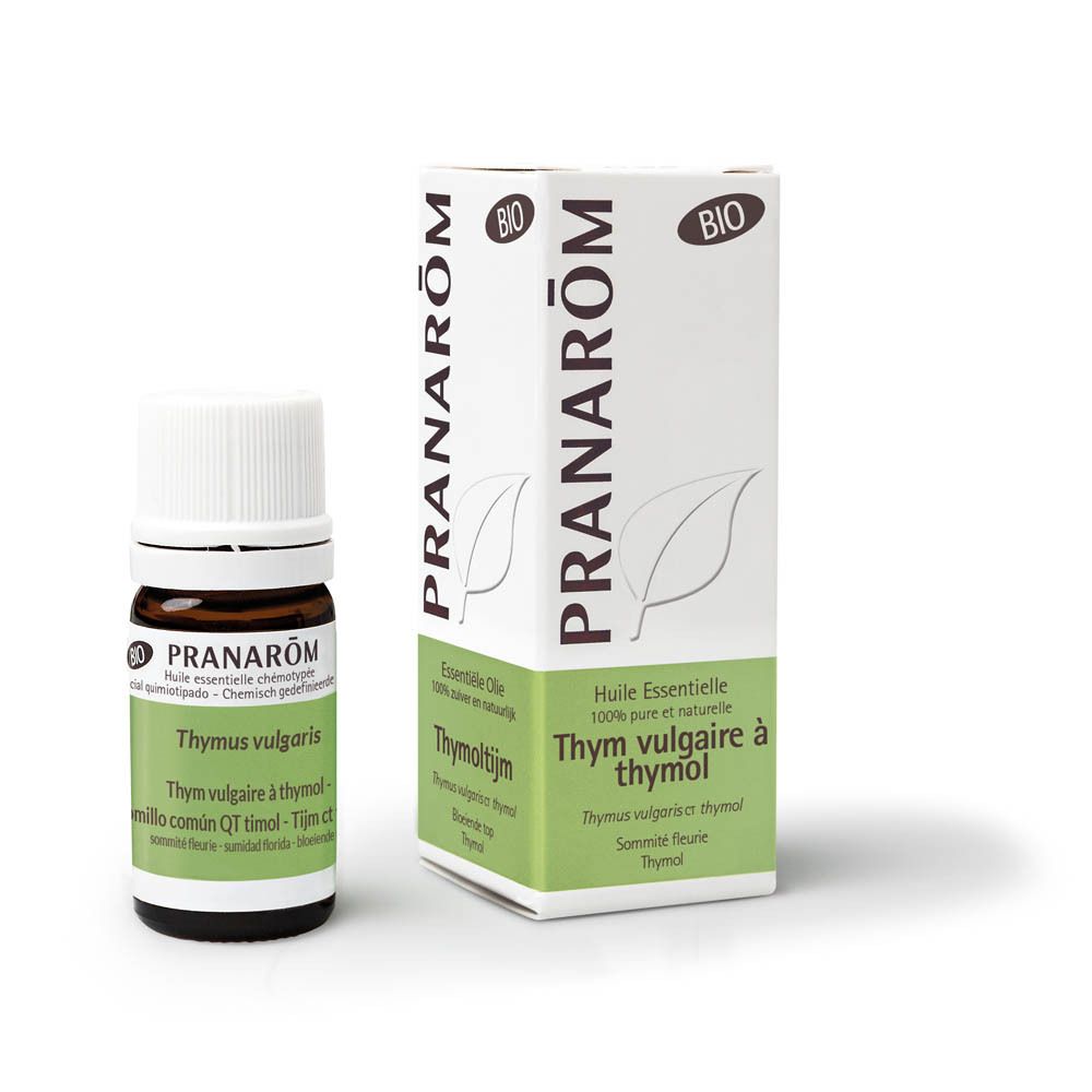 Bruine glazen fles met witte dop en etiket. Witte doos met groene accenten. Opschrift: PRANAROM.