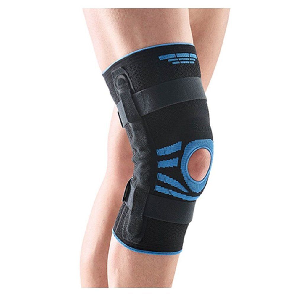 Genouillère noire avec détails bleus, portée sur une jambe. Sangles et ouverture visibles.