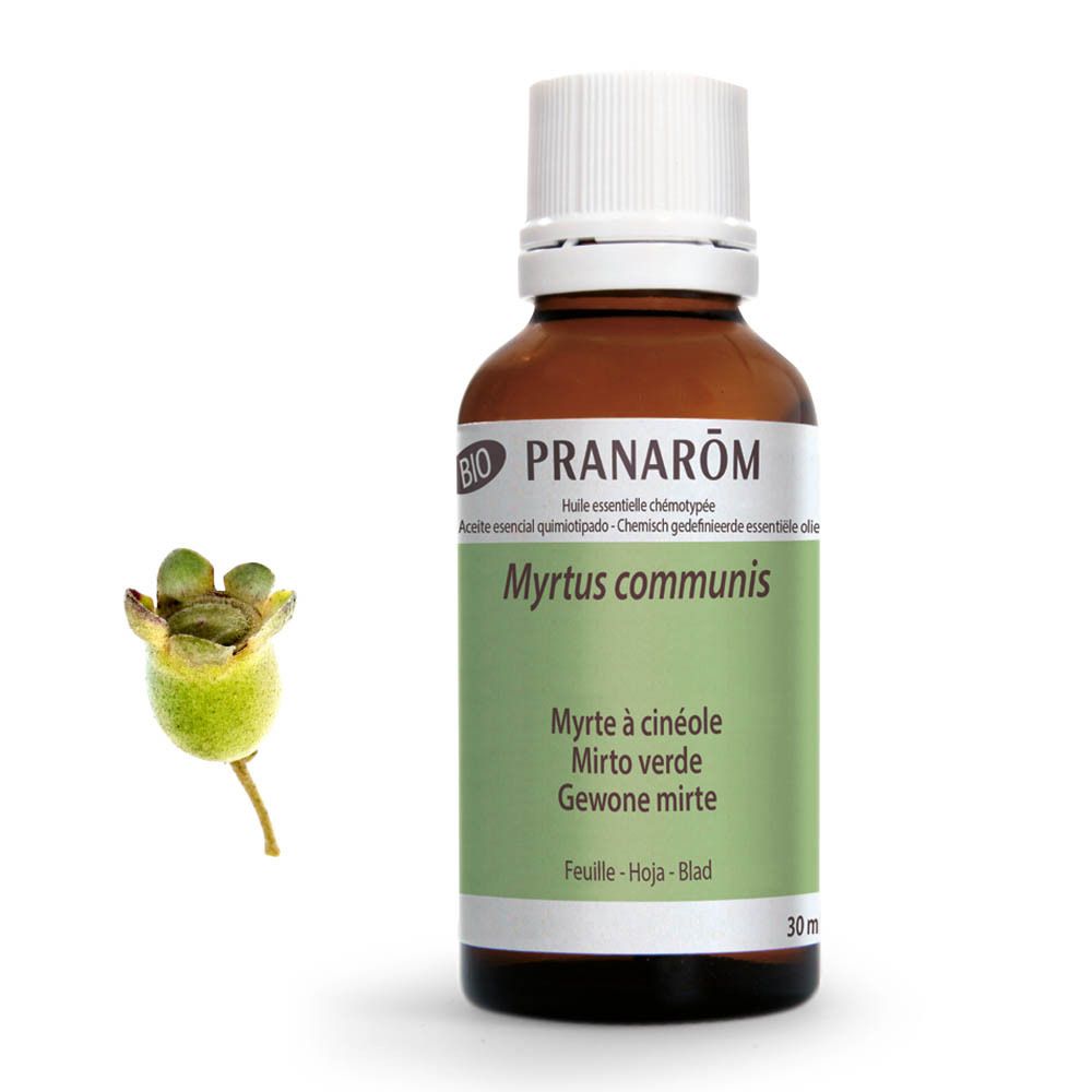 Bruine glazen fles met witte dop. Groen-wit etiket met productnaam en merk. BIO-certificering. Naast: groene vrucht.