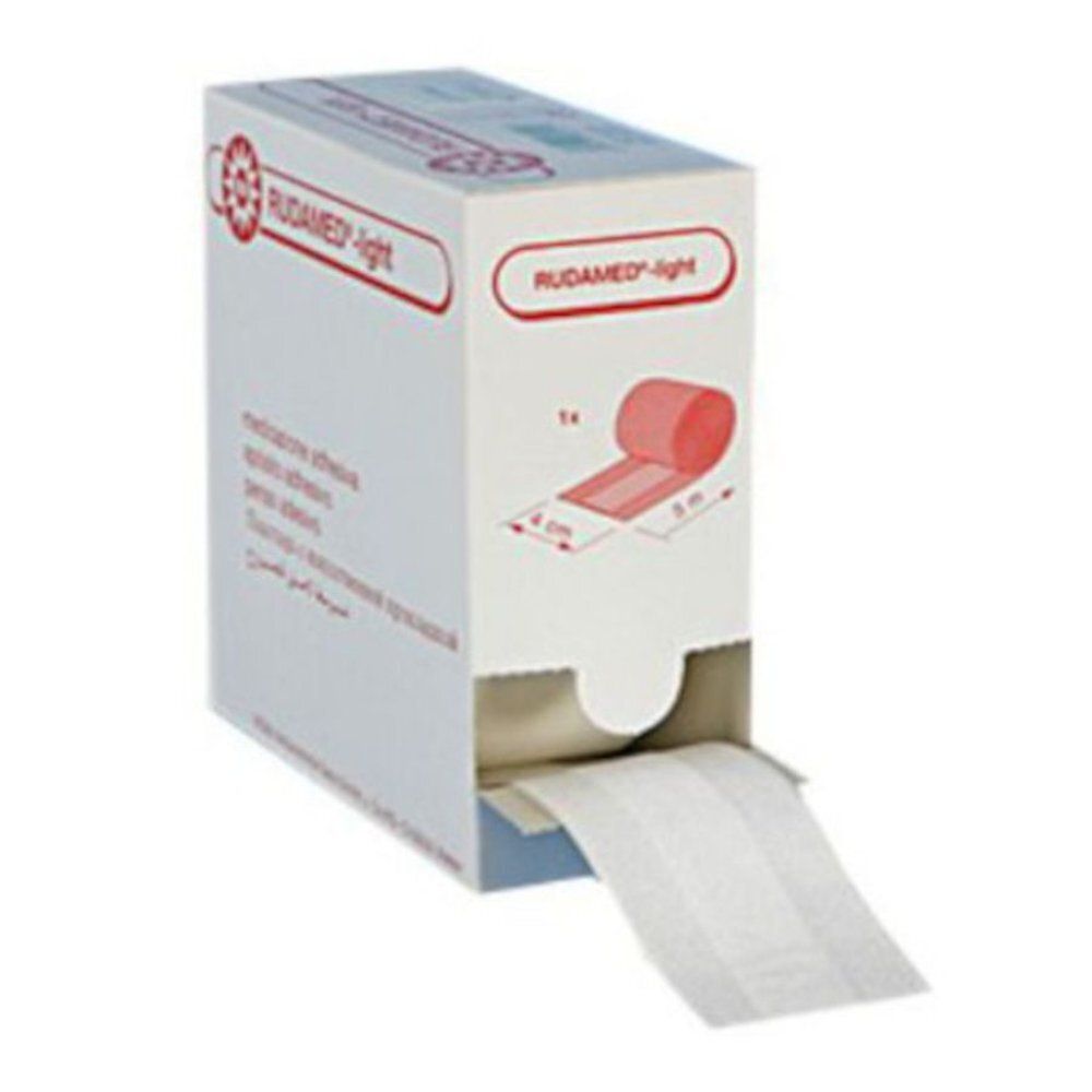 Rol verband in kartonnen verpakking. Opschrift: RUDAMED-light. Afmetingen: 4 cm x 5 m. Verband wordt uit de verpakking getrokken.