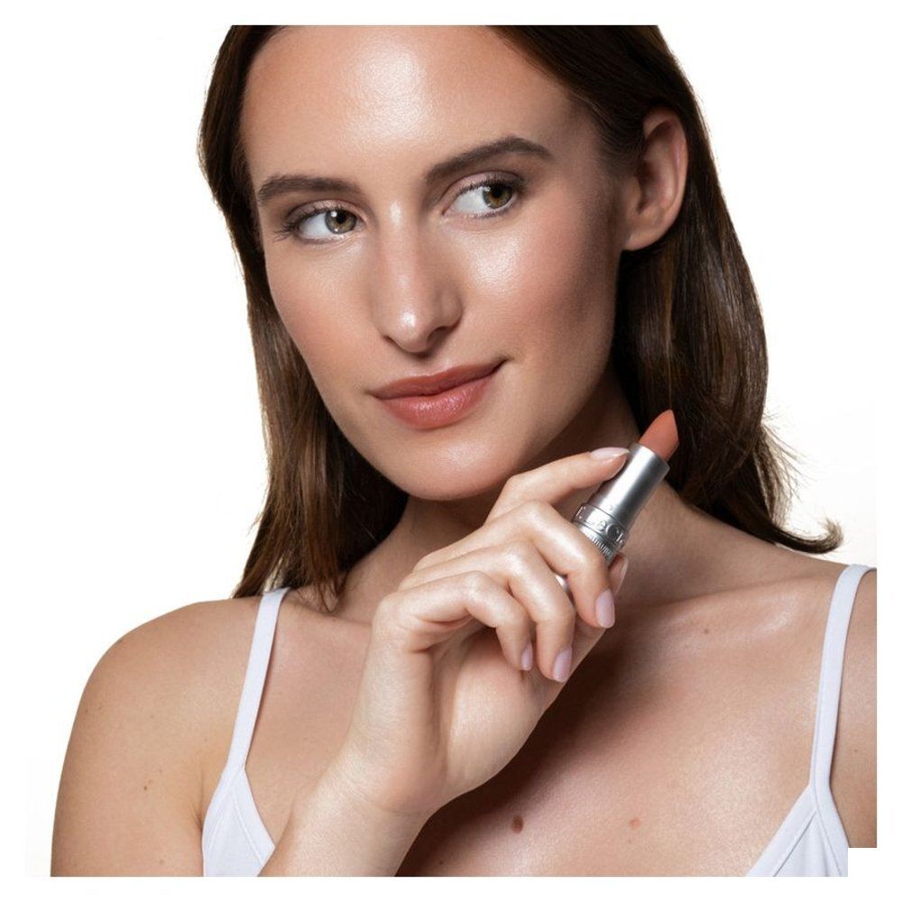 Vrouw houdt een T.LeClerc lippenstift vast. Nude kleur, zilverkleurige stick.