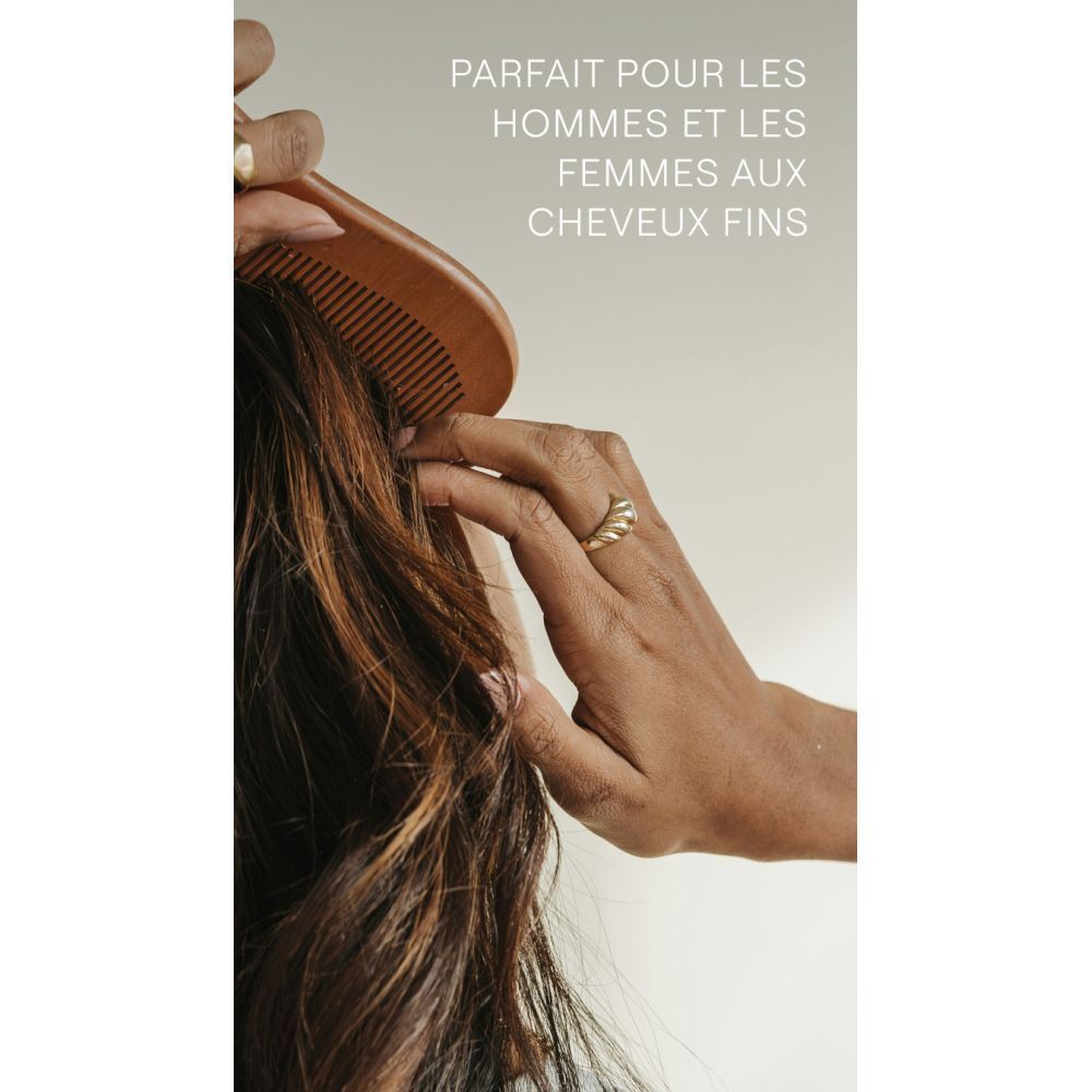 Main peignant des cheveux bruns. Texte: Parfait pour les hommes et les femmes aux cheveux fins.