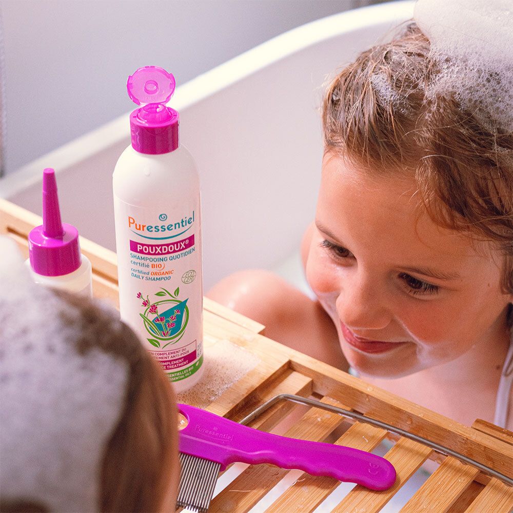 Enfant dans une baignoire avec flacon de shampoing et peigne. Inscription: Puressentiel Poudoux®.