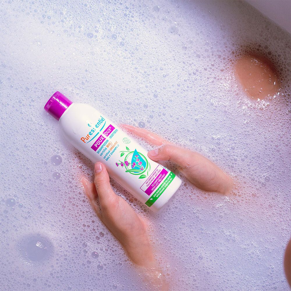 Personne dans une baignoire avec flacon de shampoing. Inscription: Puressentiel Poudoux®.