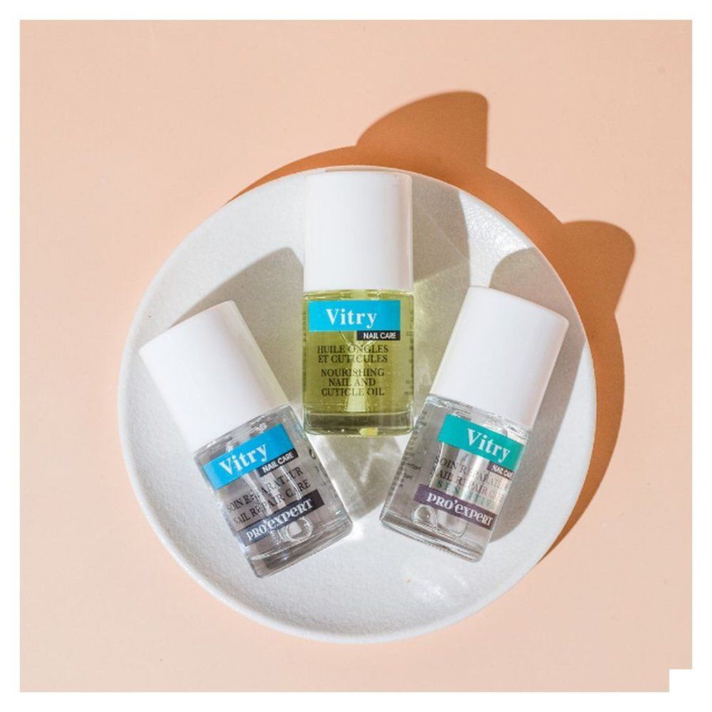 Drie flessen op een bord. Opschrift: Vitry Nail Care, Huile Ongles et Cuticules. Twee flessen met Pro Expert.