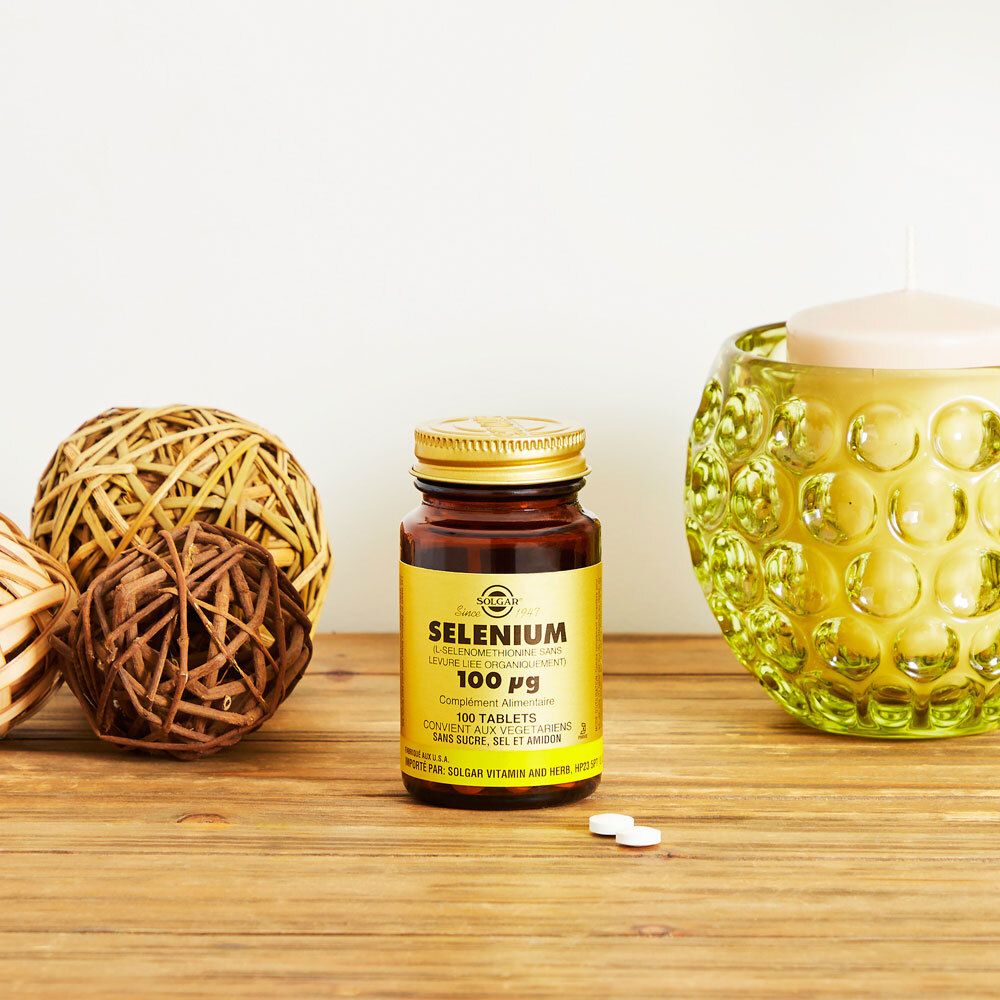 Flacon brun avec bouchon doré sur surface en bois. Décoration : boules et bougeoir.