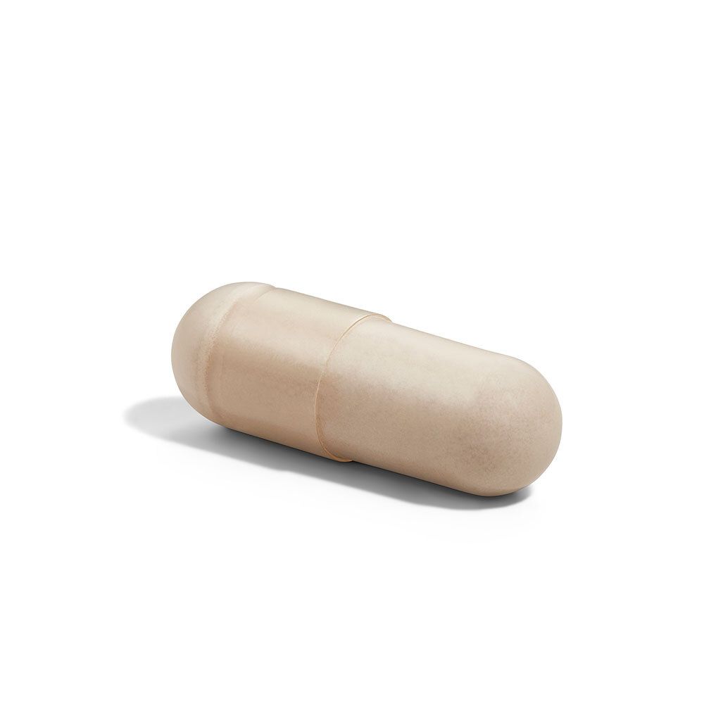Een enkele, beige capsule. Cilindrische vorm met afgeronde uiteinden.
