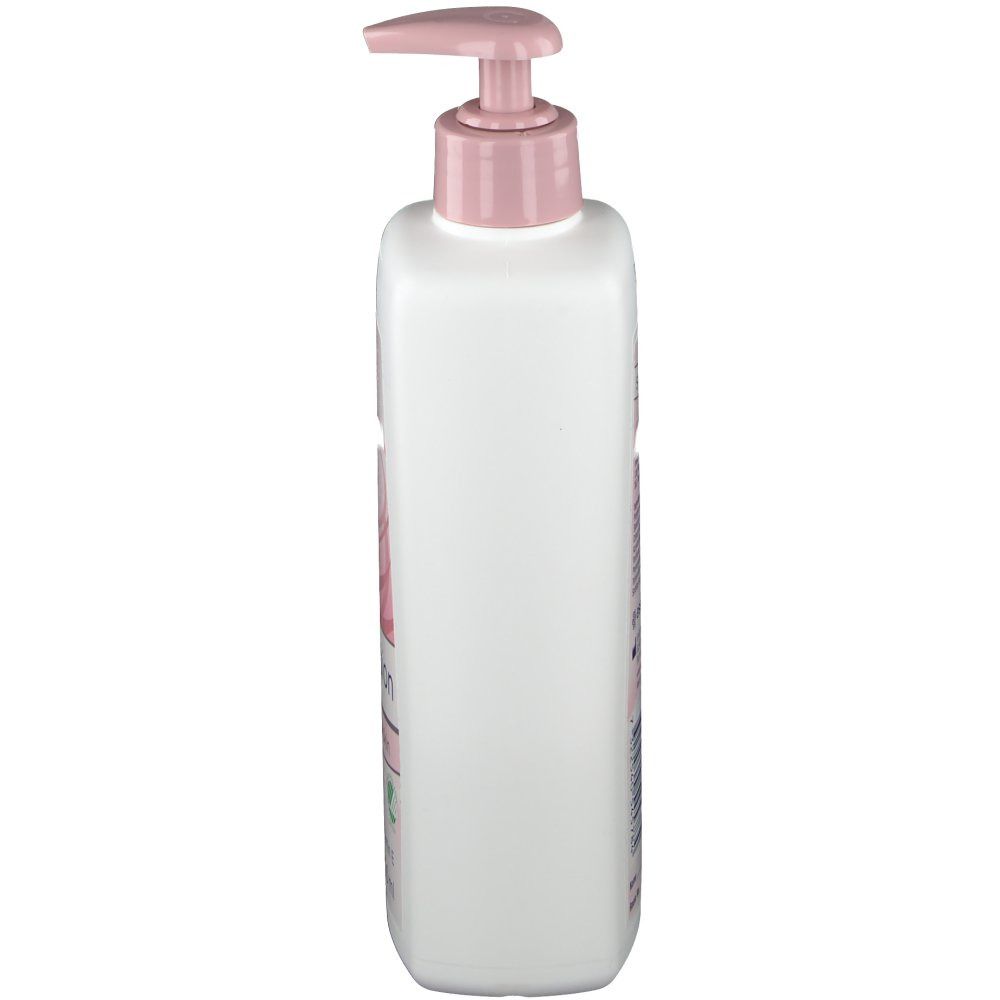 Witte fles met roze pompkop. Zijaanzicht. Bedrukking op de fles. Product voor huidverzorging.