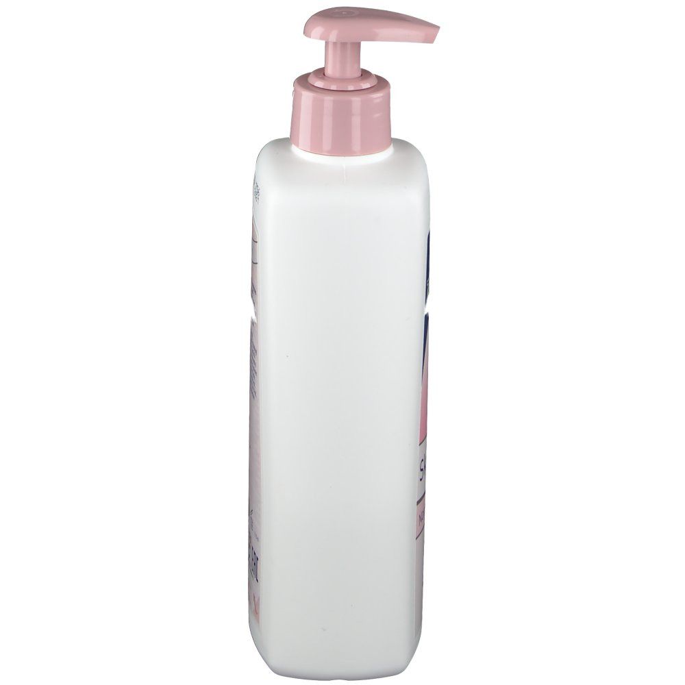 Witte fles met roze pompkop. Zijaanzicht. Bedrukking op de fles. Product voor huidverzorging.