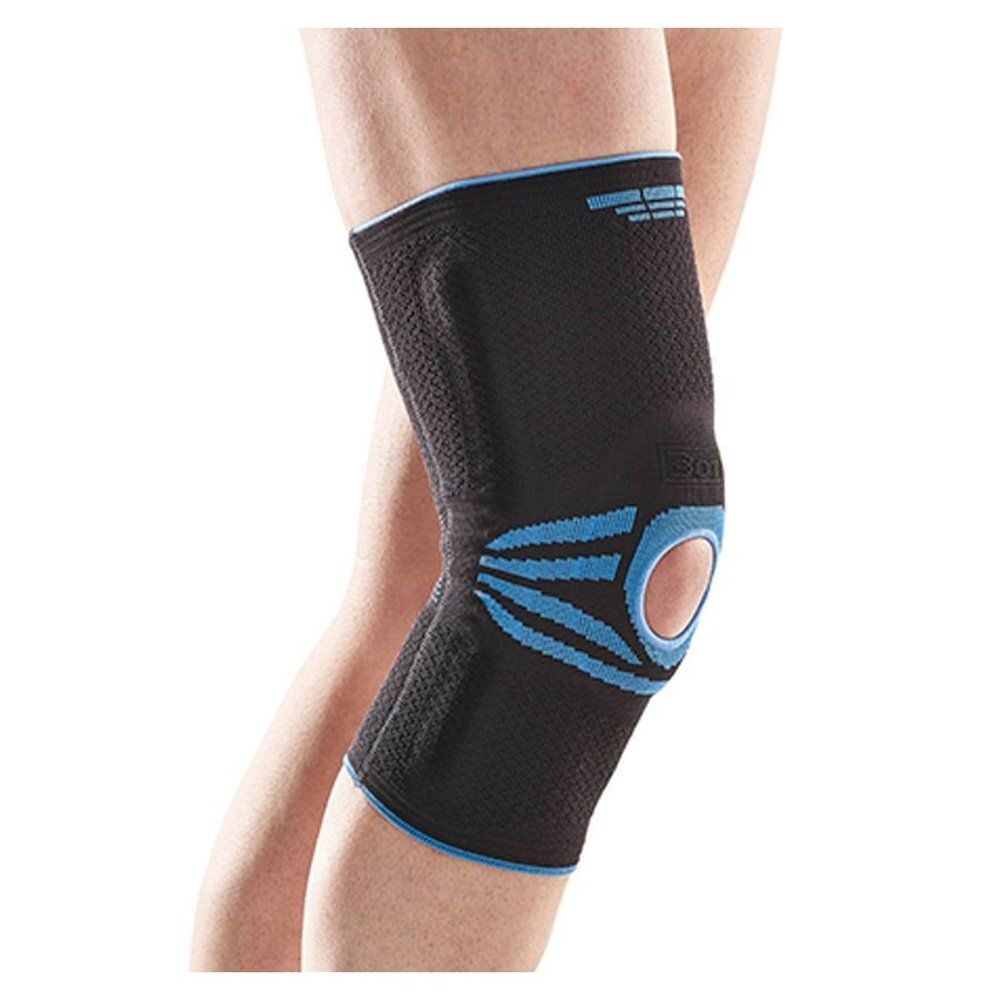 Attelle de genou noire avec accents bleus. Taille visible. Portée sur une jambe.