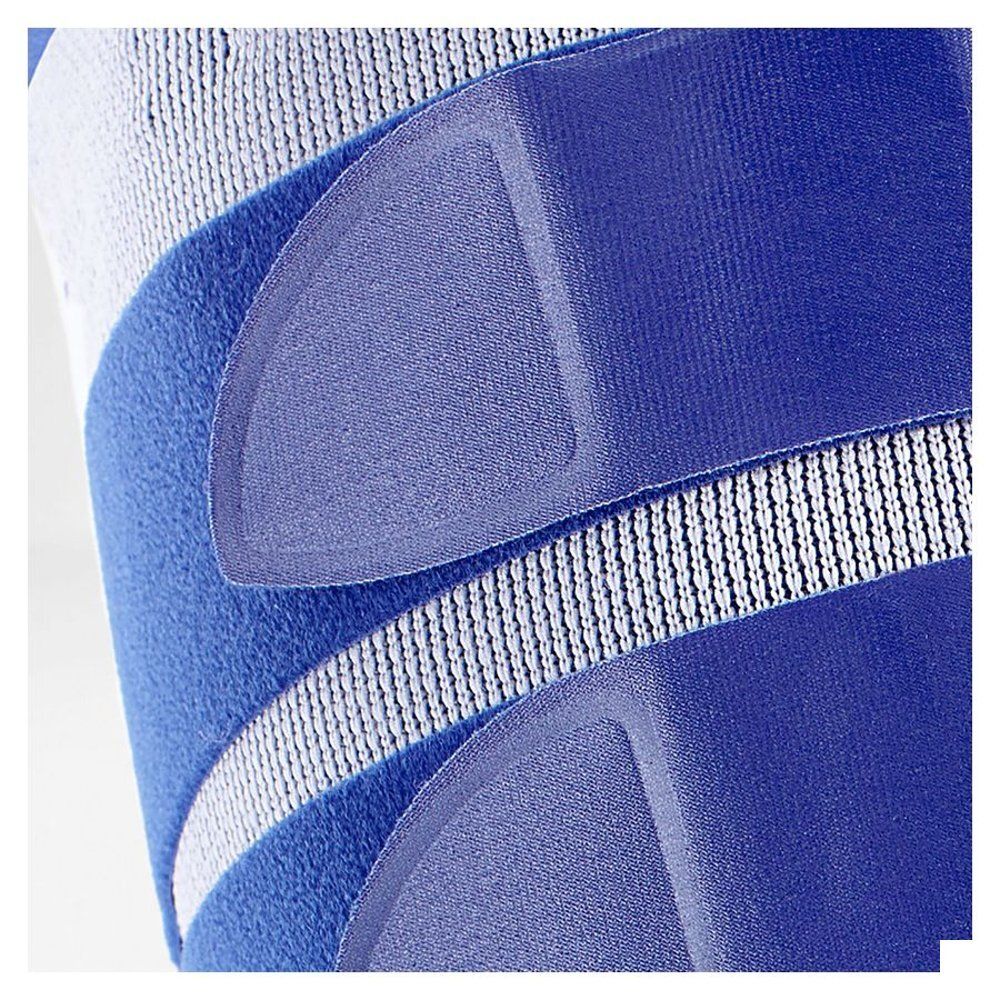 Close-up van de blauwe dijbeenbrace. Blauwe banden en wit gaas. Geen merk zichtbaar.