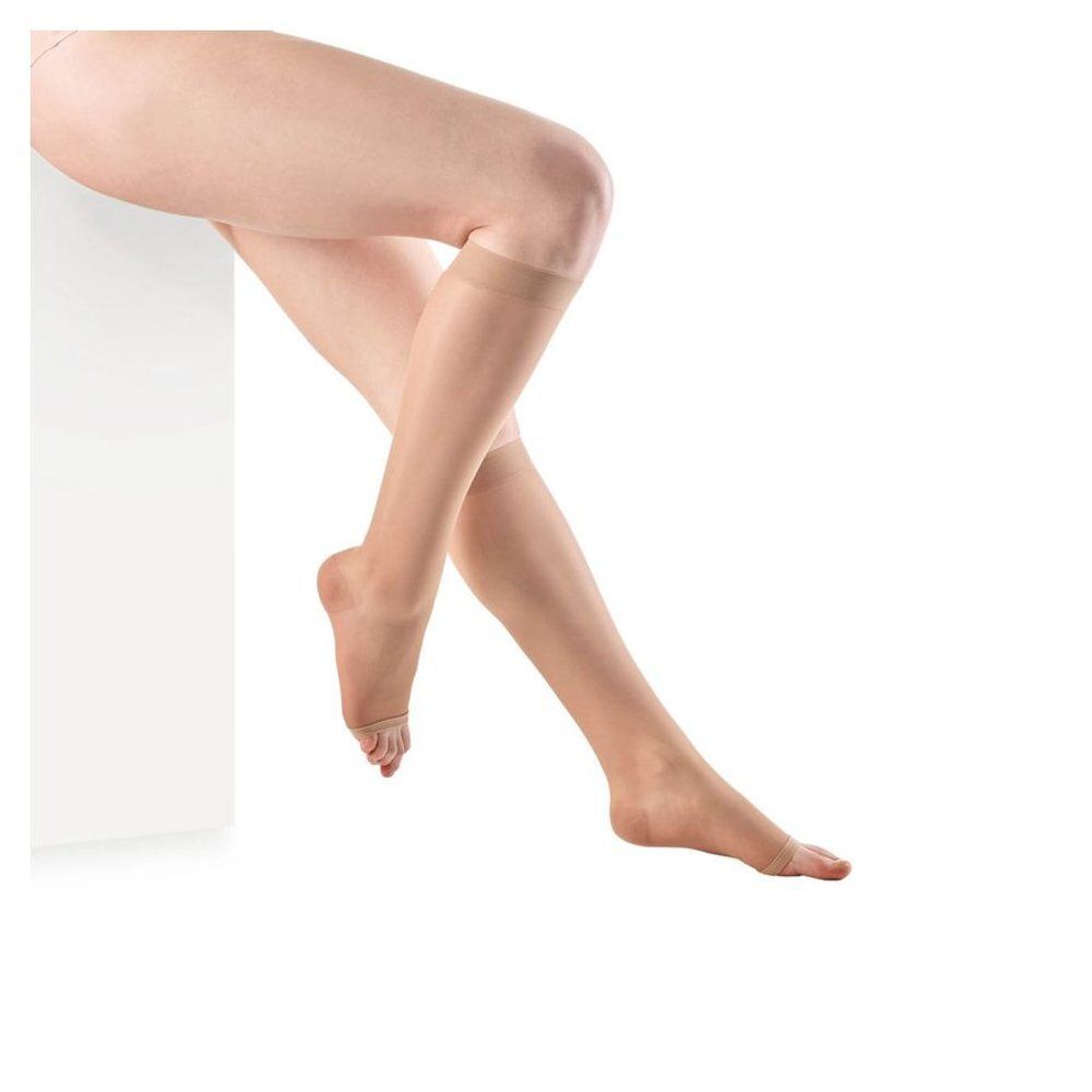 Benen met huidkleurige compressiekousen. Kousen reiken tot de knie.