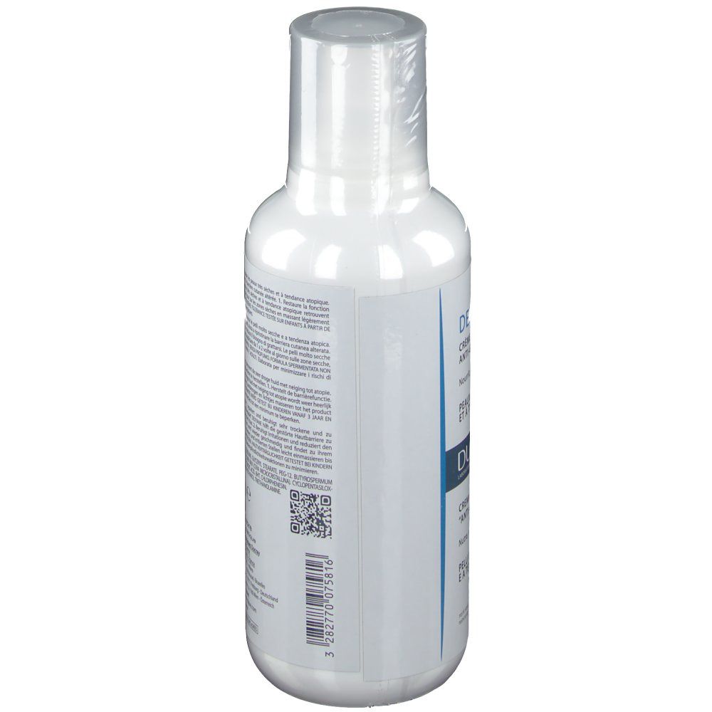 Witte fles met tekst. Zijaanzicht. DUCRAY DEXYANE crème. Meertalige tekst.