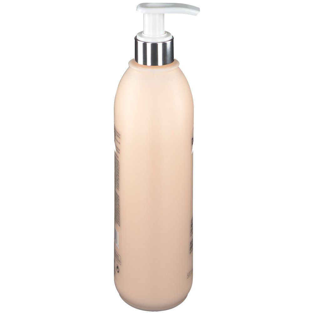 Beige fles met pomp, zijaanzicht. Tekst op de zijkant.