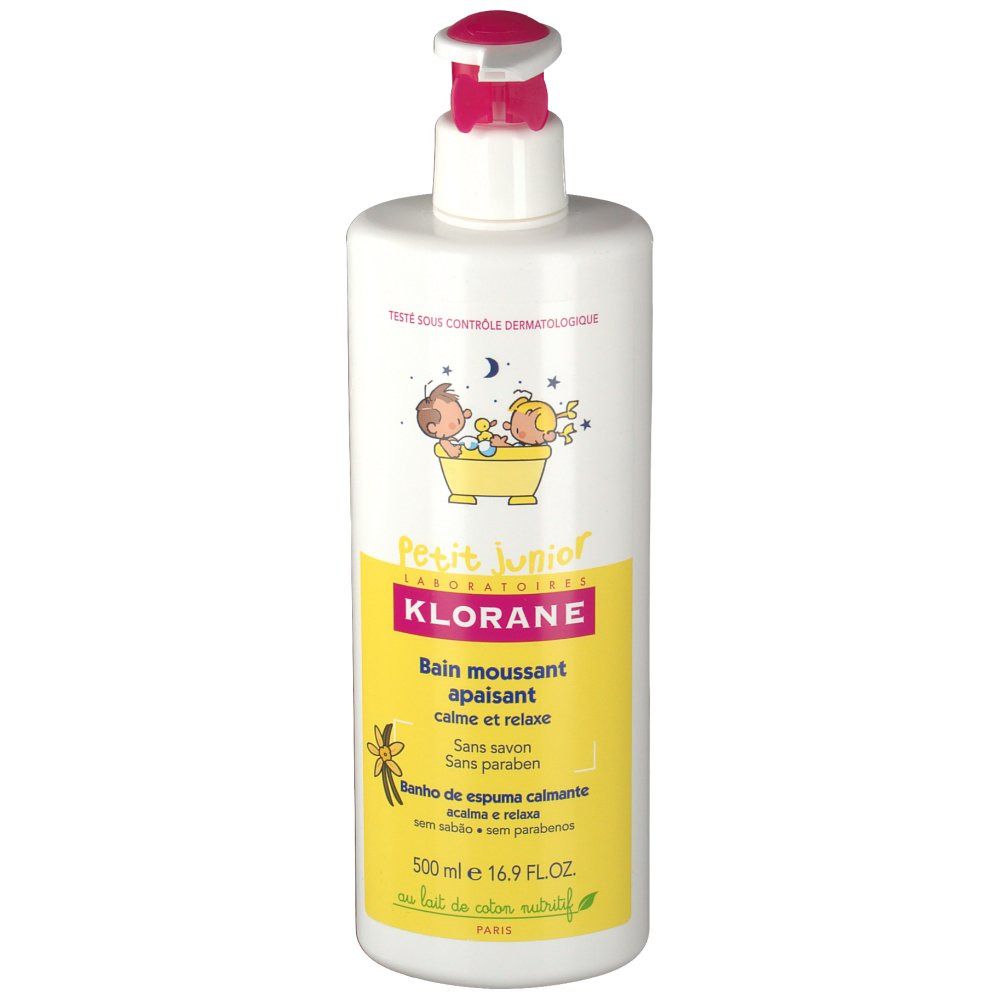Witte fles met roze pomp. Geel etiket met tekst en illustraties. Opschrift: Klorane Petit Junior, kalmerende badschuim.