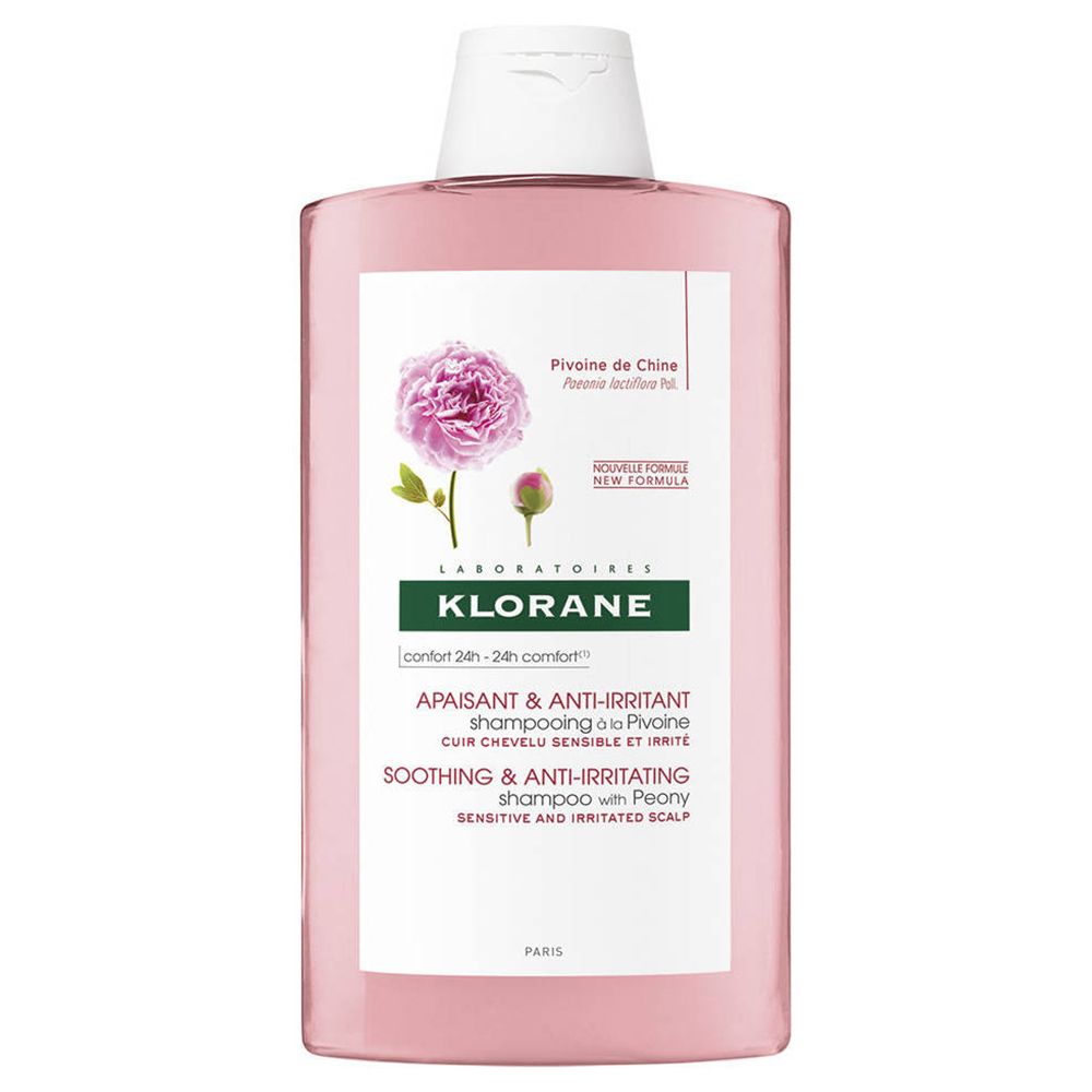 Flacon de shampooing rose. Étiquette avec pivoine et texte : Klorane, apaisant, anti-irritant.