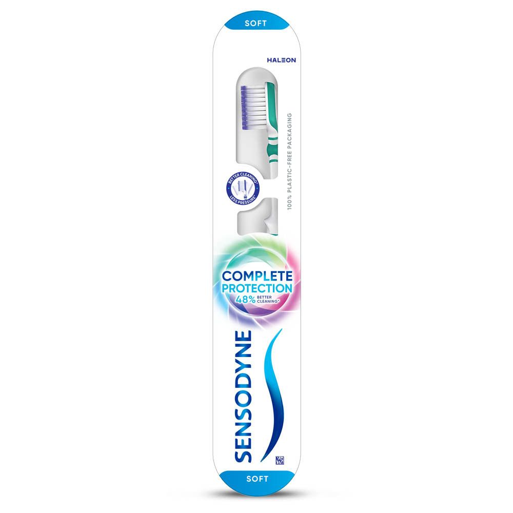 Tandenborstel in verpakking. Witte handgreep, groene borstelkop. "SENSODYNE" logo. "Complete Protection" logo. "Soft" aanduiding.