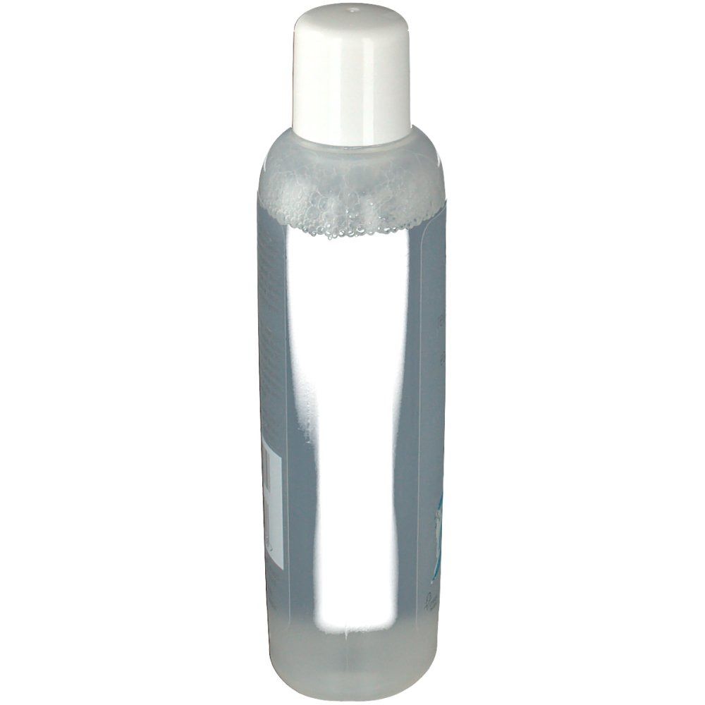 Transparante fles met witte dop. Achterkant met etiket, tekst en barcode.