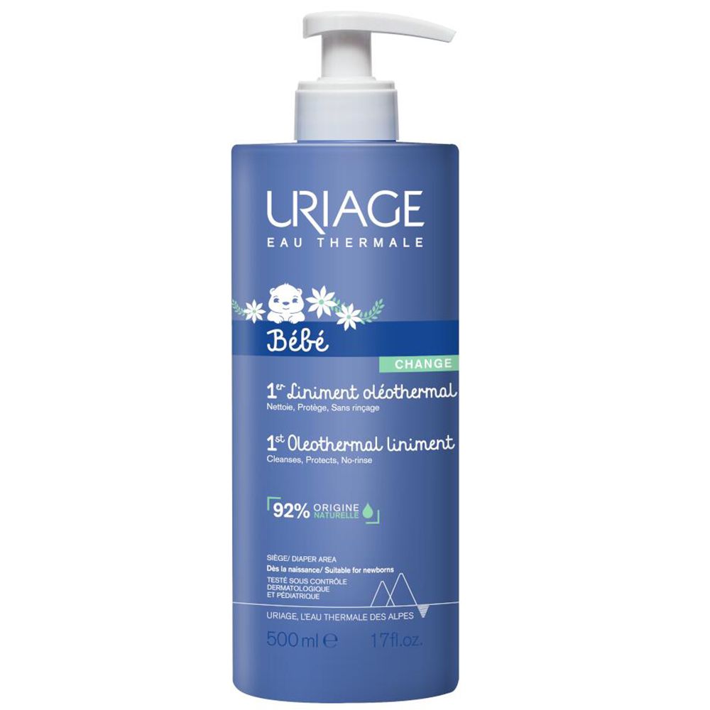 Gros plan d'une main appliquant une crème blanche sur la peau. Texte: Extra-zachte luiercrème.