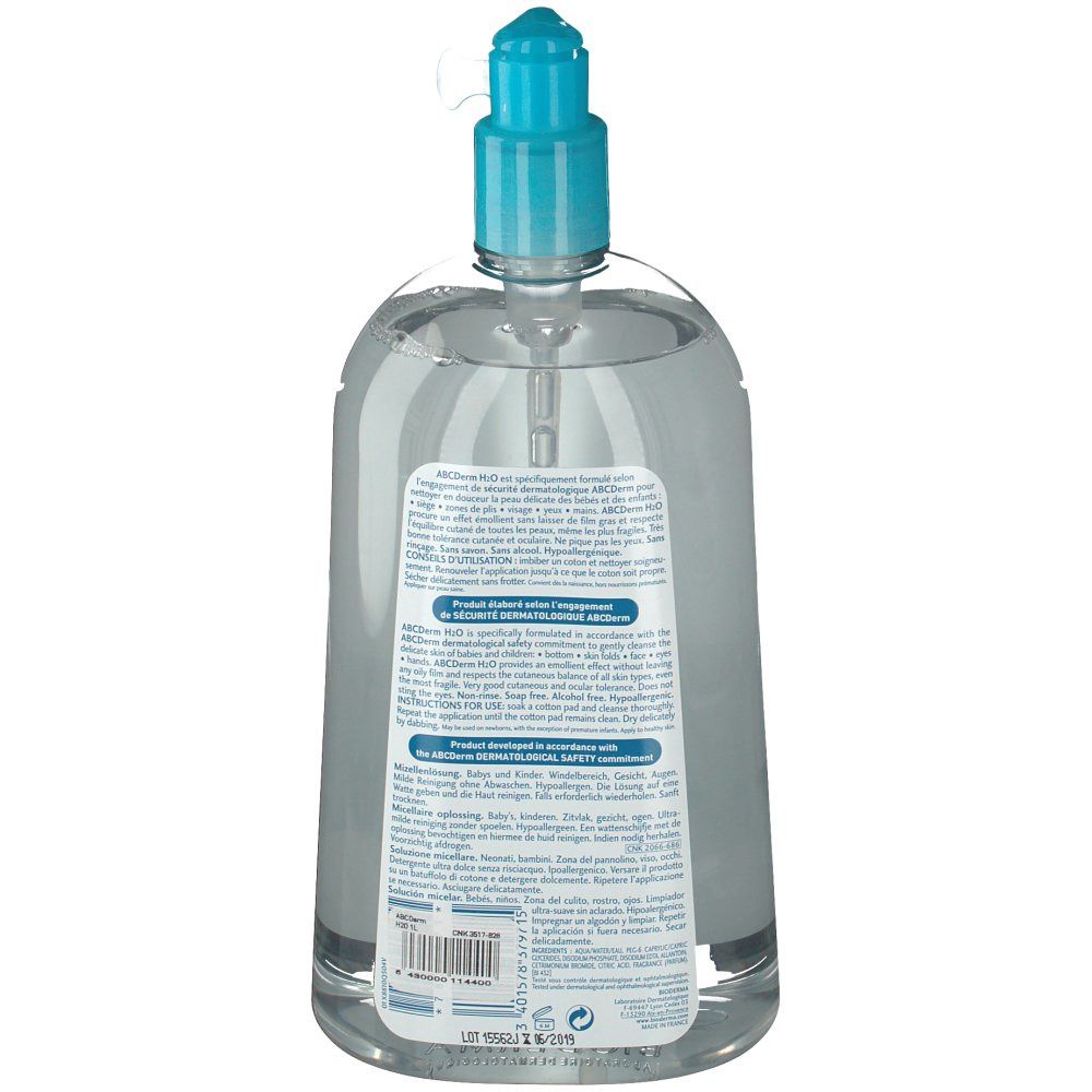 Achteraanzicht van een transparante fles met blauwe pompdeksel. Tekst op het etiket, productinformatie en barcode.